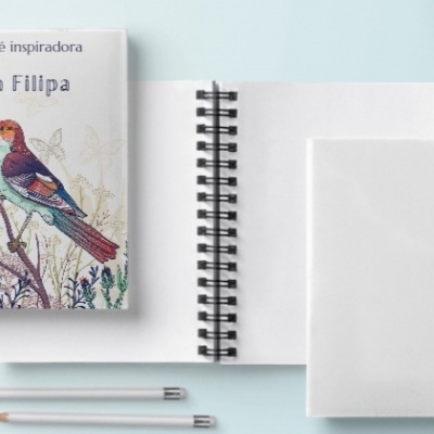 Três cadernos espiralados com capa branca e ilustrada com pássaro, dois lápis e prato cor de rosa sobre superfície branca