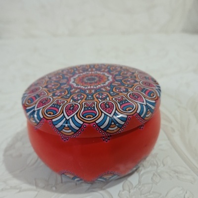Pote redondo de vidro laranja com tampa decorada com mandala colorida em padrão floral