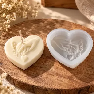 Vela creme em forma de coração com molde de silicone branco e desenho em relevo de mãos entrelaçadas