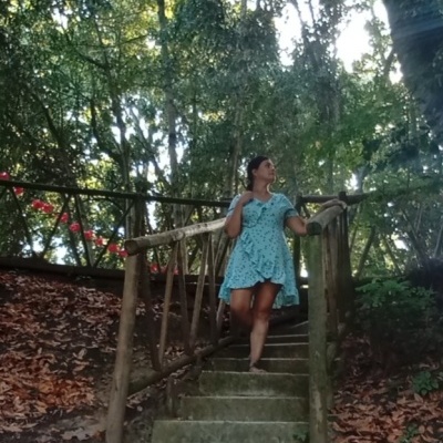 O Teu Despertar: A Jornada de aprender com tudo e todos á tua volta Mulher de vestido azul floral a subir escadas de pedra rodeada de árvores