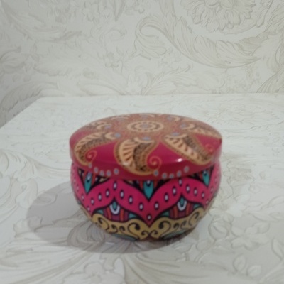 Caixa redonda decorativa com padrões florais e geométricos em várias cores