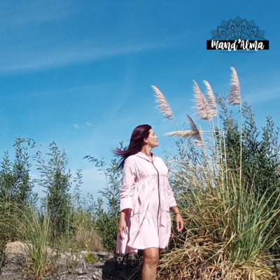 A fé como alicerce da nossa vida Mulher de vestido rosa claro em ambiente natural com céu azul e plantas altas