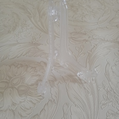 Suporte transparente de plástico sobre superfície floral clara