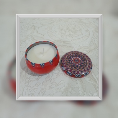 Vela decorativa com base vermelha e tampa com padrão mandala colorida