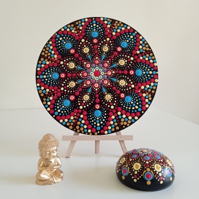 Objetos decorativos: mandala pintada, pedra pintada e estátua dourada de Buda