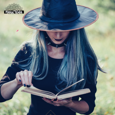 Mulher com chapéu de bruxa preto lê livro ao ar livre