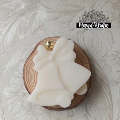 Sabonete em forma de sinos brancos com laço sobre suporte de madeira redondo e pano bege com padrão floral