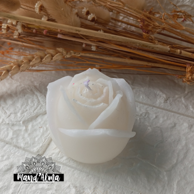 Vela branca em forma de rosa com ramos secos ao fundo