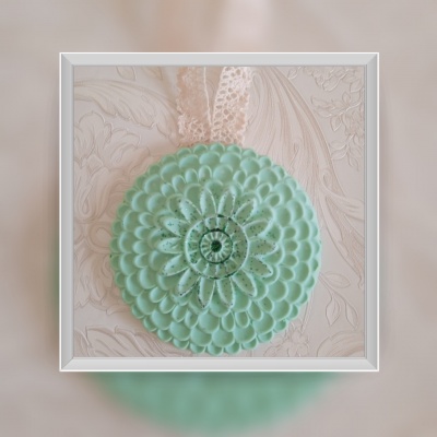 Sabonete verde redondo com padrão floral.