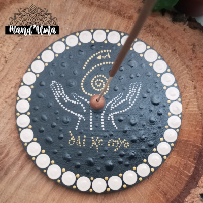 Incensário redondo preto com pontos brancos e dourados, mãos desenhadas e texto 'Shri hl yoga'.