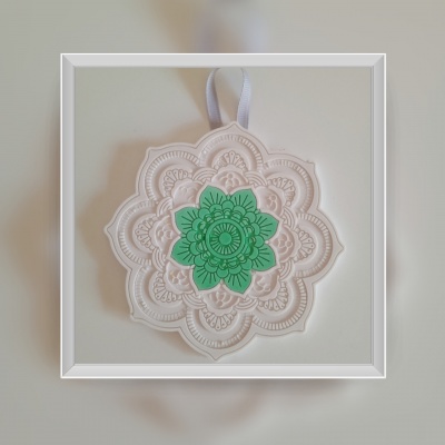 Enfeite decorativo em tecido branco com flor verde no centro e fita para pendurar