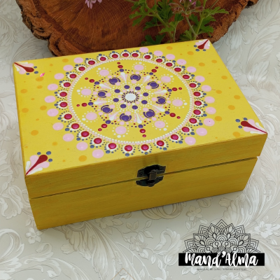 Caixa de madeira amarela com padrão mandala colorida na tampa
