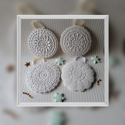 Quatro painéis redondos de croché branco com desenhos variados e laços para pendurar, dispostos em fundo bege com estrelas decorativas ao redor.