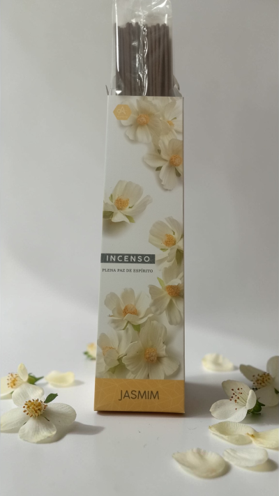 Caixa branca de incenso jasmim com palitos castanhos e flores brancas decorativas.