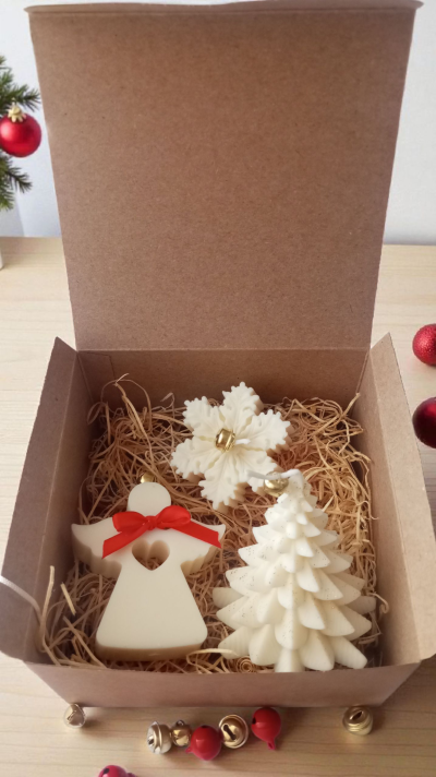 Caixa aberta com velas de Natal em formato de anjo, floco de neve e árvore de Natal