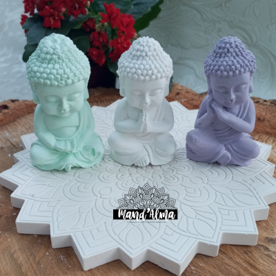 Estatuetas de Buda coloridas em base branca com padrão floral