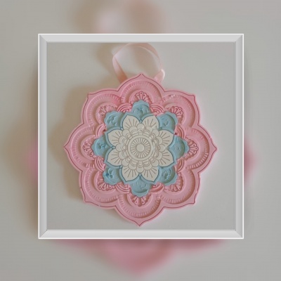 Adorno mandala decorativa em rosa, azul e creme com padrão floral em relevo