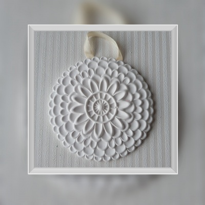 Ornamento decorativo branco com padrão floral e fita de pendurar