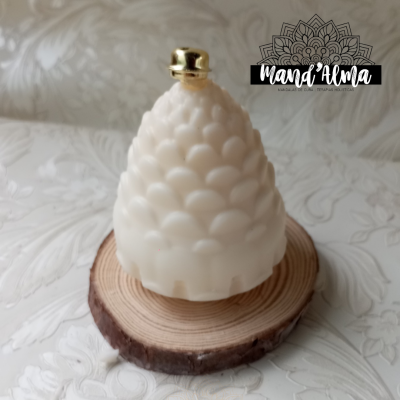 Vela branca em forma de pinha sobre disco de madeira