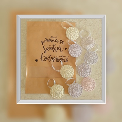 Sacola de papel com texto motivacional e ornamentos redondos rendados de cores claras