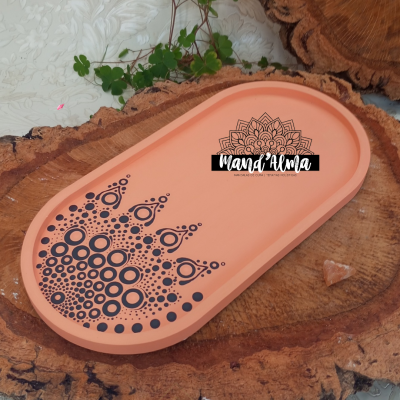 Tabuleiro oval terracota com padrão preto e texto MANDA ALMA sobre superfície de madeira