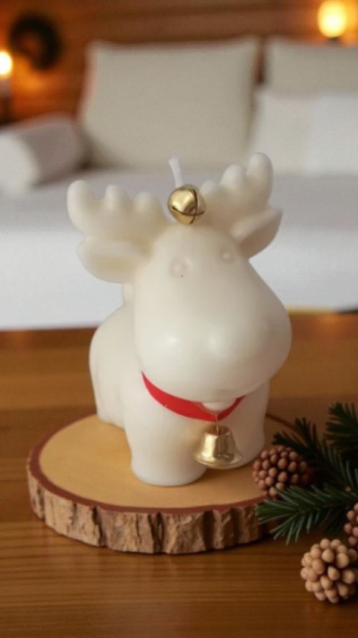 Vela em forma de rena branca com sinetas douradas e base redonda de madeira