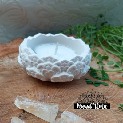 Vela branca em suporte cerâmico decorativo com cristais e plantas verdes