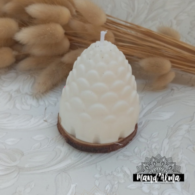 Vela branca em forma de cone com base de cortiça ao lado de ramos secos