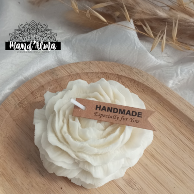 Vela branca em forma de flor com etiqueta Handmade