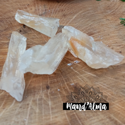 Pedras translúcidas sobre prato de vidro e madeira rústica com logótipo Mana'Alma