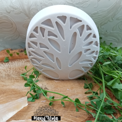 Produto cerâmico branco redondo com padrão de árvore recortada em madeira com ervas verdes