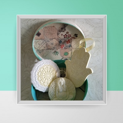 Caixa azul com sabonetes artesanais variados em branco e amarelo com texturas e padrões diferentes