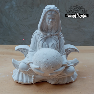 Estátua branca de mulher sentada a segurar esfera texturizada sobre superfície de madeira