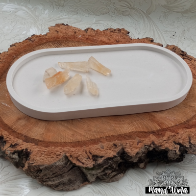 Bandeja branca com seis cristais translúcidos sobre madeira natural