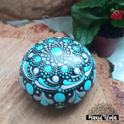 Esfera decorativa pintada à mão com padrões azuis e brancos sobre madeira