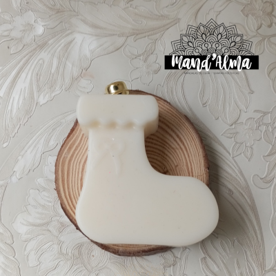 Sabonete em forma de botinha branca sobre base de madeira redonda