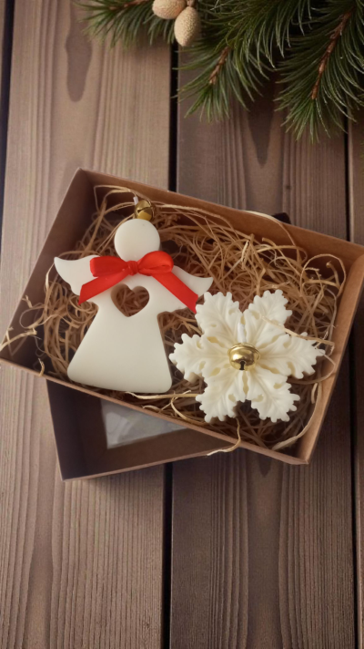 Caixa com enfeites de Natal anjo e floco de neve brancos com laço vermelho e sino