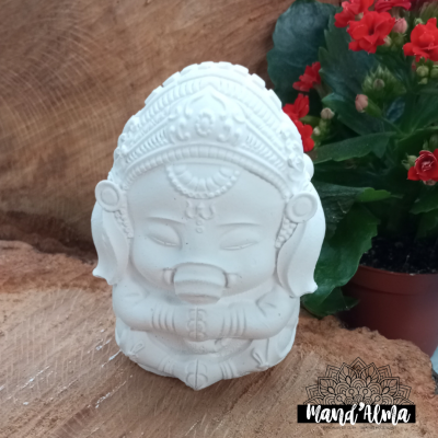 Estatueta branca de Ganesha em cerâmica junto a planta em vaso