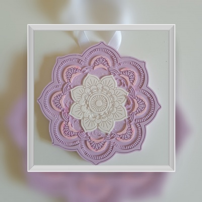 Ornamento mandala em tons de rosa e branco com padrão floral e fita para pendurar