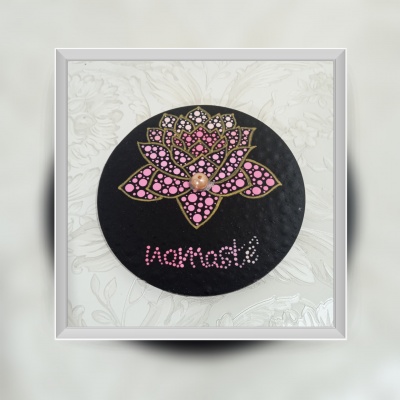 Decoração redonda com flor de lótus rosa e palavra Namaste sobre fundo preto