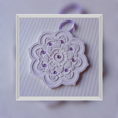 Ornamento floral branco com pérolas roxas e fita roxa sobre tecido listrado branco
