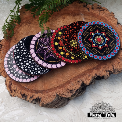 Bases para copos redondas em madeira com padrões coloridos sobre madeira rústica