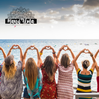 Seis mulheres de costas fazendo corações com as mãos junto ao mar sobre uma varanda