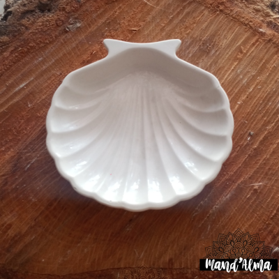 Prato cerâmico branco em forma de concha sobre madeira