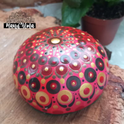 Tambor de língua vermelho decorado com padrões circulares em amarelo e preto sobre madeira