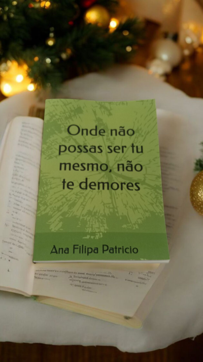 Livro de capa verde claro com texto preto sobre livro aberto e decoração de Natal ao fundo