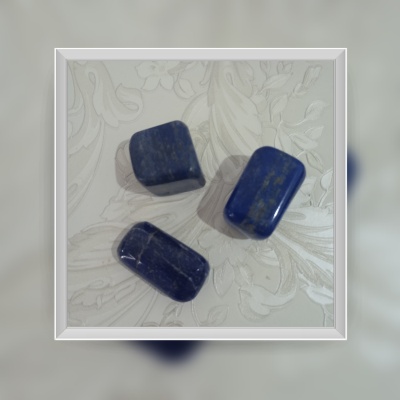 Pedras azuis polidas retangulares e ovais sobre fundo floral claro