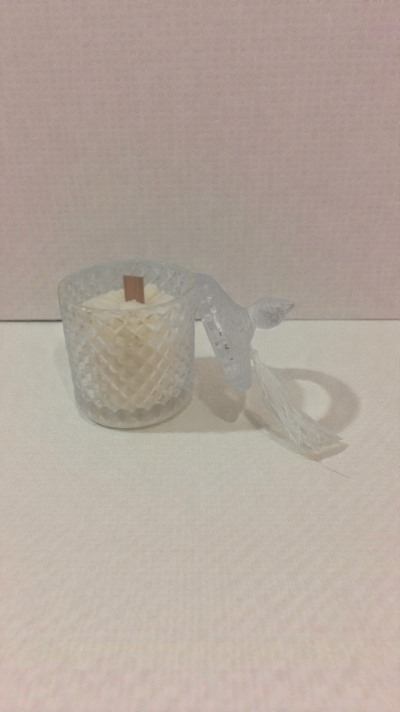 Vela branca em jarra de vidro facetado com tampa transparente pendurada