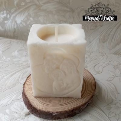 Vela branca quadrada com relevo de rosto feminino sobre base de madeira redonda