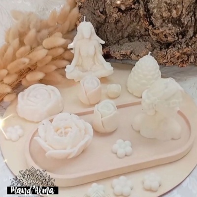 Conjunto de velas decorativas brancas com diversas formas numa base oval clara